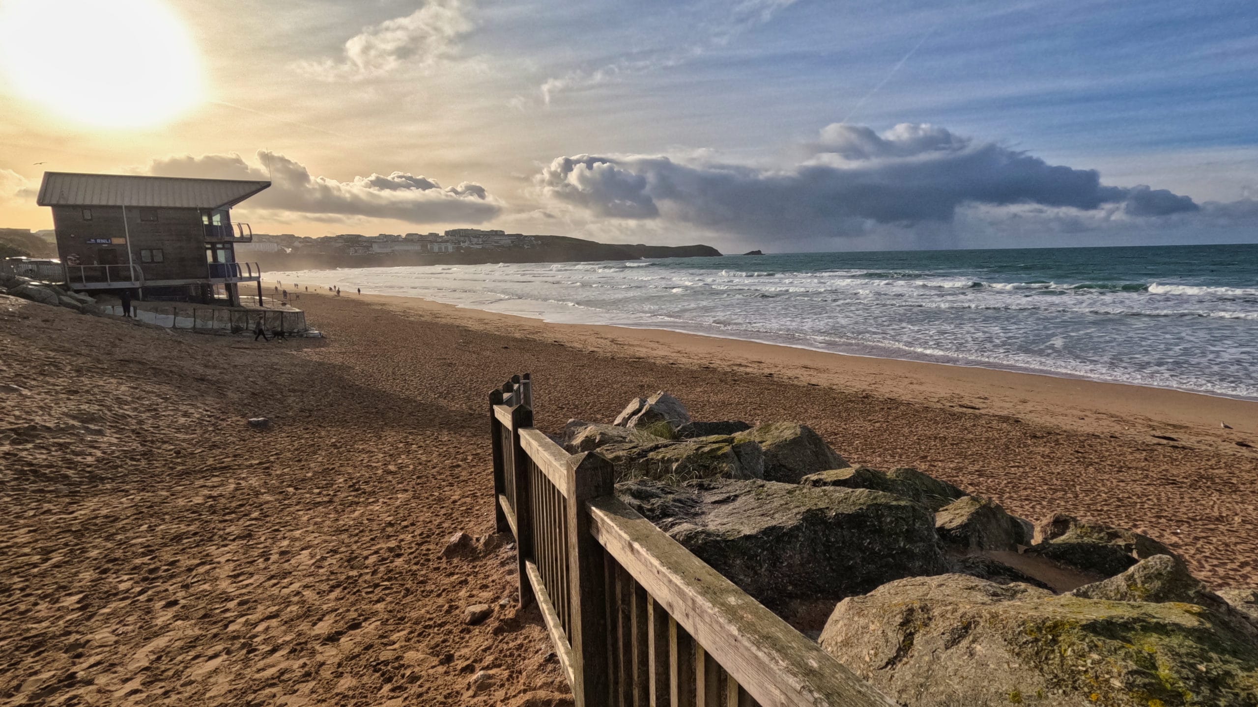 North coast Cornwall beach with lifeguard hut, golden sand and surf under a bright sky